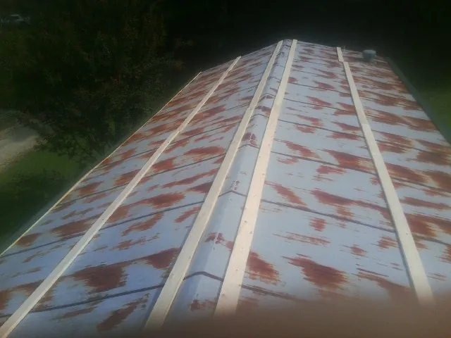 Rusted metal roof panels with new wood purlins before replacement — Storm Damage Roof Repair in Bay Pines by Roofing Brothers