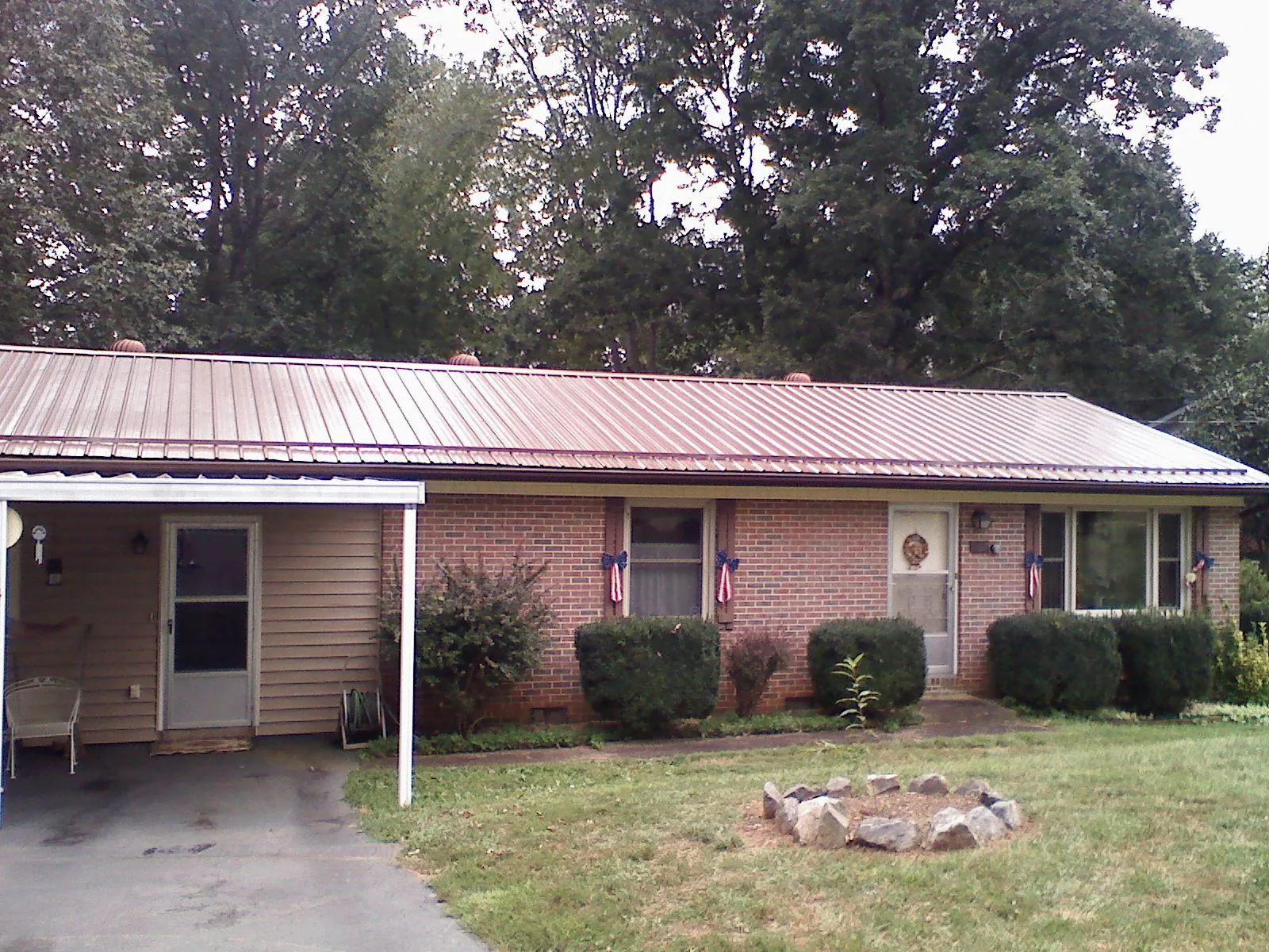 Bronze metal roof and carport on a brick ranch home — Roof Repair work by our crew in Bay Pines